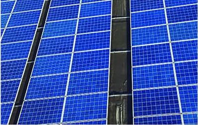 Rows of blue solar modules on a factory roof, close up
